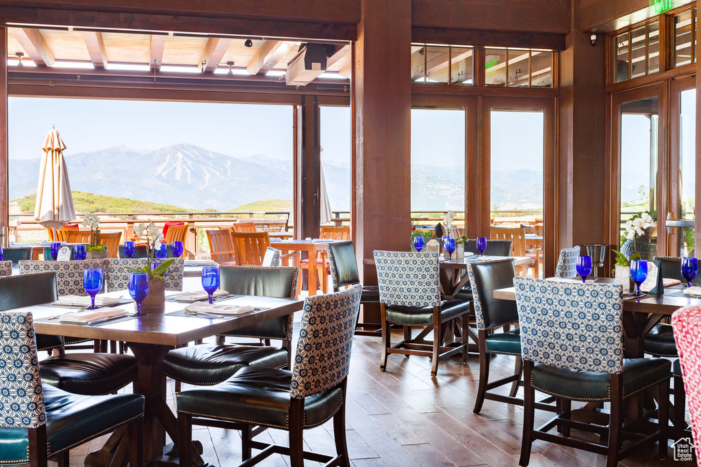 Dining area featuring a mountain view, plenty of natural light, hardwood / wood-style flooring, beam ceiling, and wooden ceiling