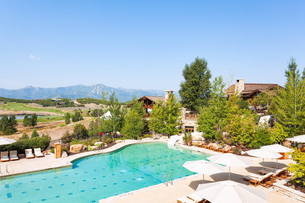 View of pool with a mountain view, a water slide, and a patio area