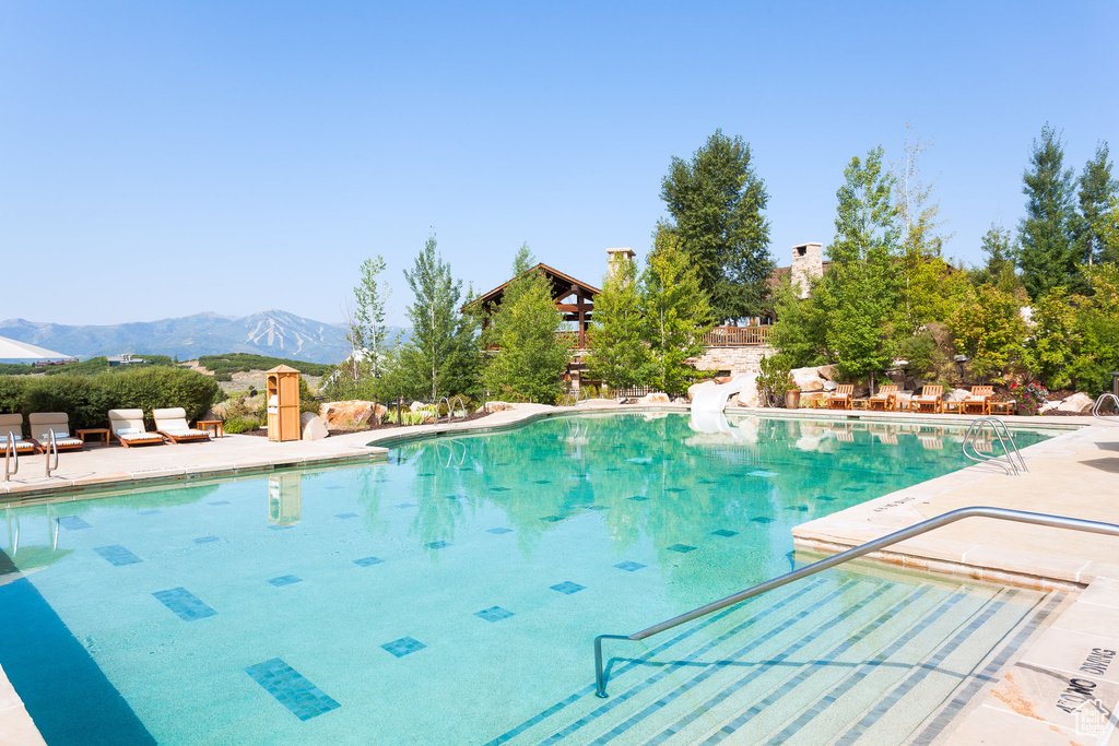 Community pool featuring a mountain view and a patio