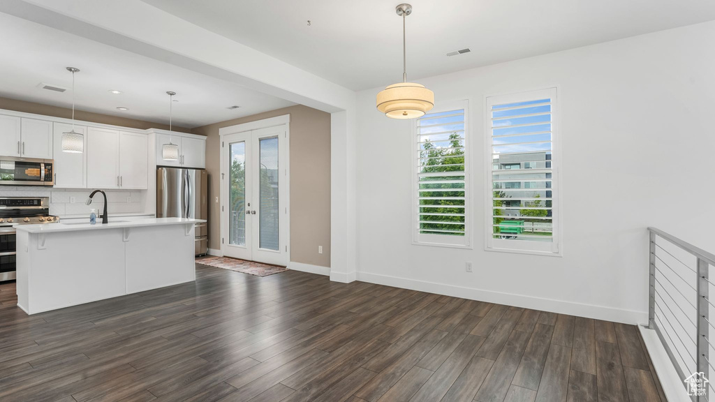 Kitchen with appliances with stainless steel finishes, a sink, plenty of natural light, baseboards, and recessed lighting