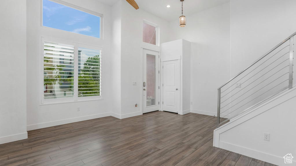 Foyer featuring stairs, a towering ceiling, baseboards, dark wood-type flooring, and recessed lighting