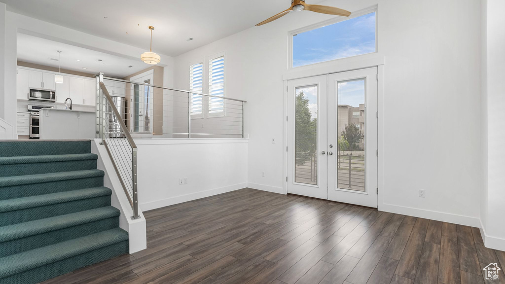 Entrance foyer with french doors, baseboards, a ceiling fan, and dark wood finished floors