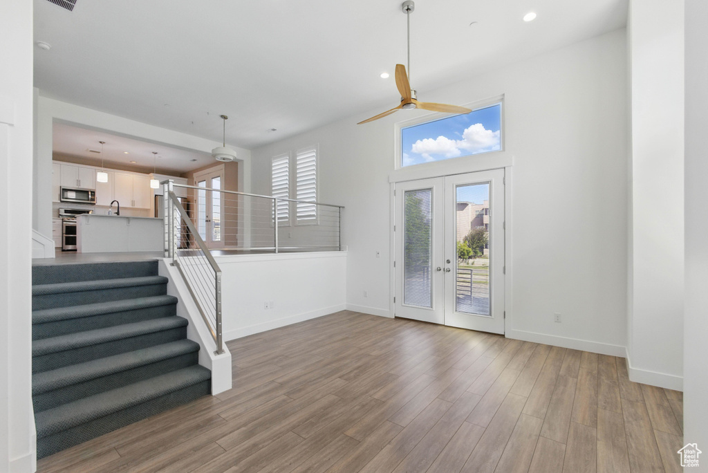 Entryway featuring a ceiling fan, baseboards, wood finished floors, stairs, and recessed lighting