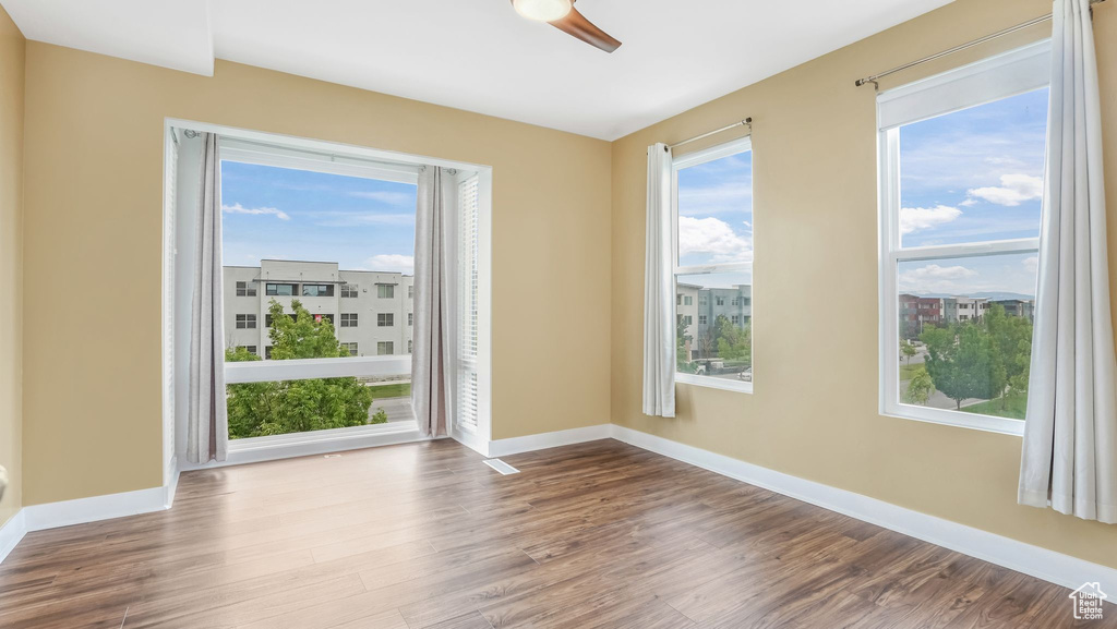 Spare room featuring wood finished floors, baseboards, and ceiling fan