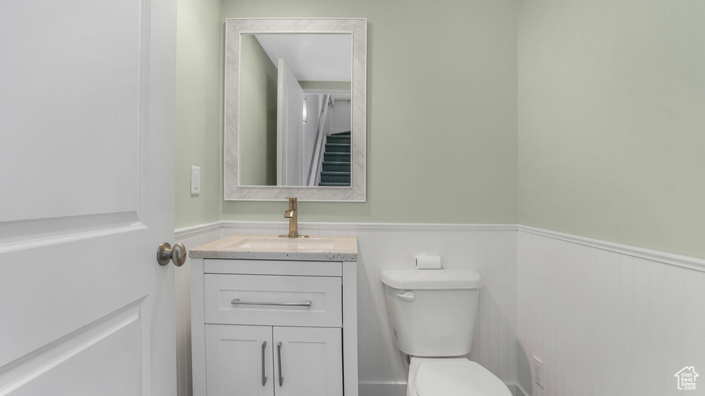 Bathroom with wainscoting, toilet, and vanity
