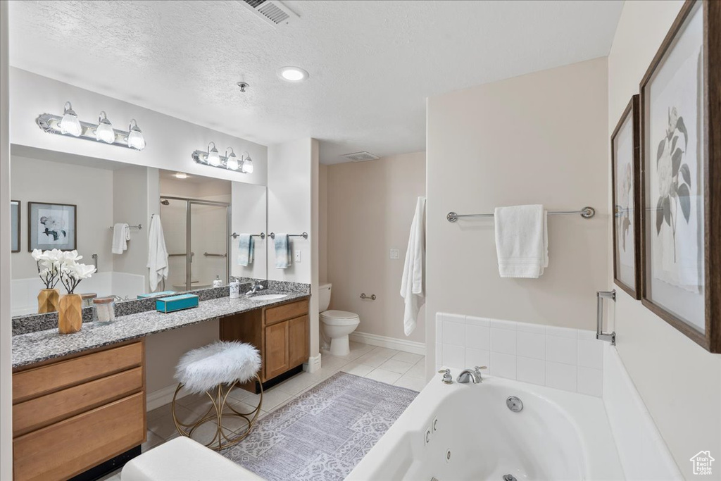 Full bathroom with toilet, a stall shower, a tub with jets, vanity, and tile patterned flooring
