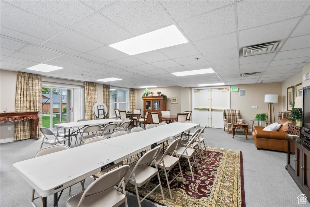 Carpeted dining area with a drop ceiling