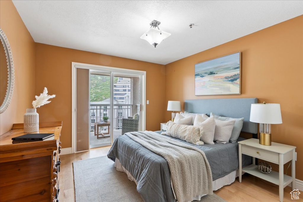 Bedroom with light wood-style floors, access to outside, and baseboards