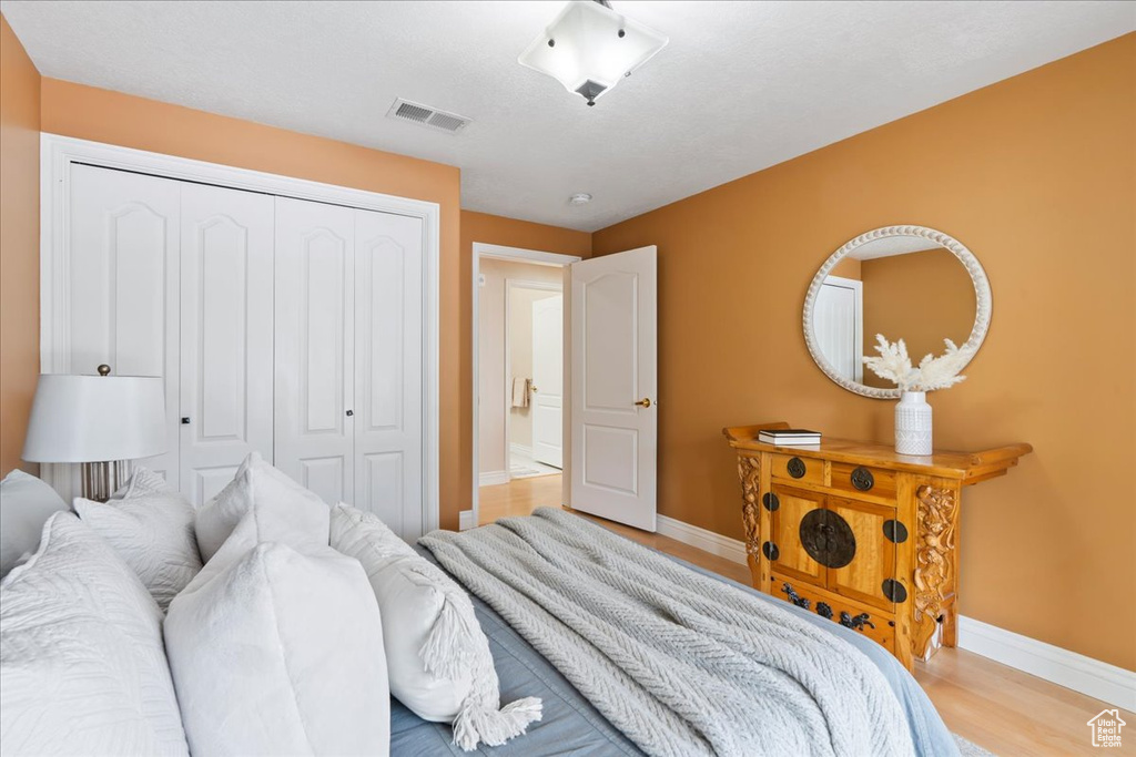 Bedroom with baseboards, a closet, and wood finished floors