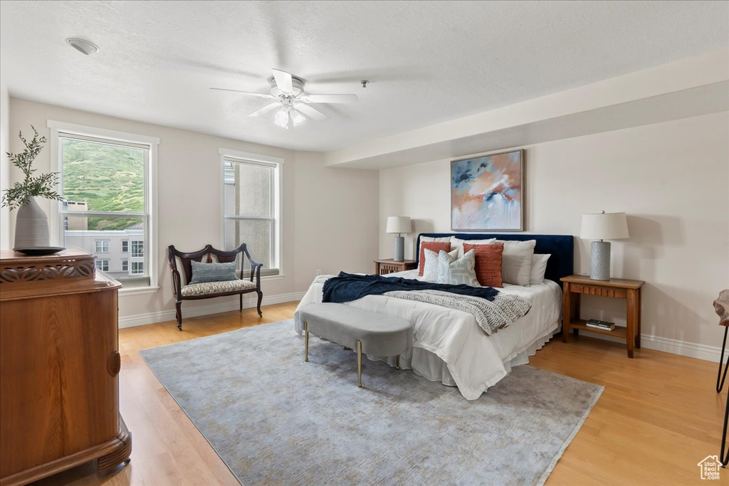Bedroom featuring light wood-type flooring, baseboards, and a ceiling fan