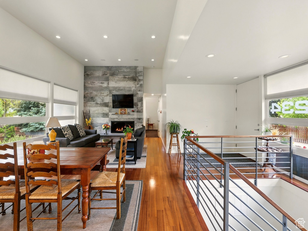 Dining space with recessed lighting, a tiled fireplace, and wood finished floors