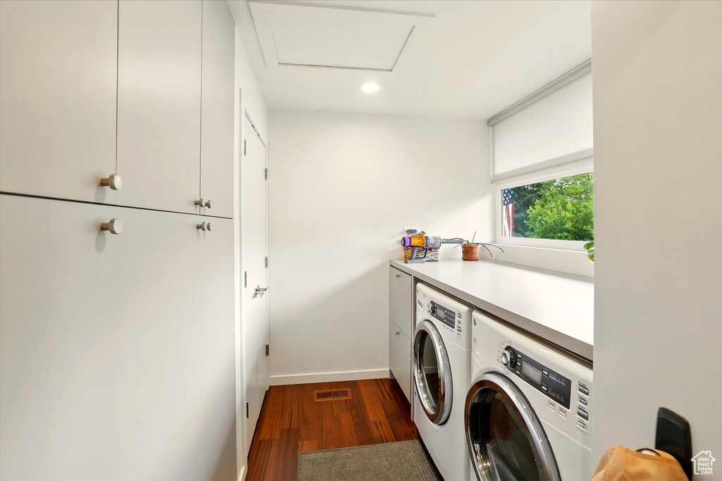 Laundry area with cabinet space, washer and clothes dryer, dark wood finished floors, baseboards, and recessed lighting