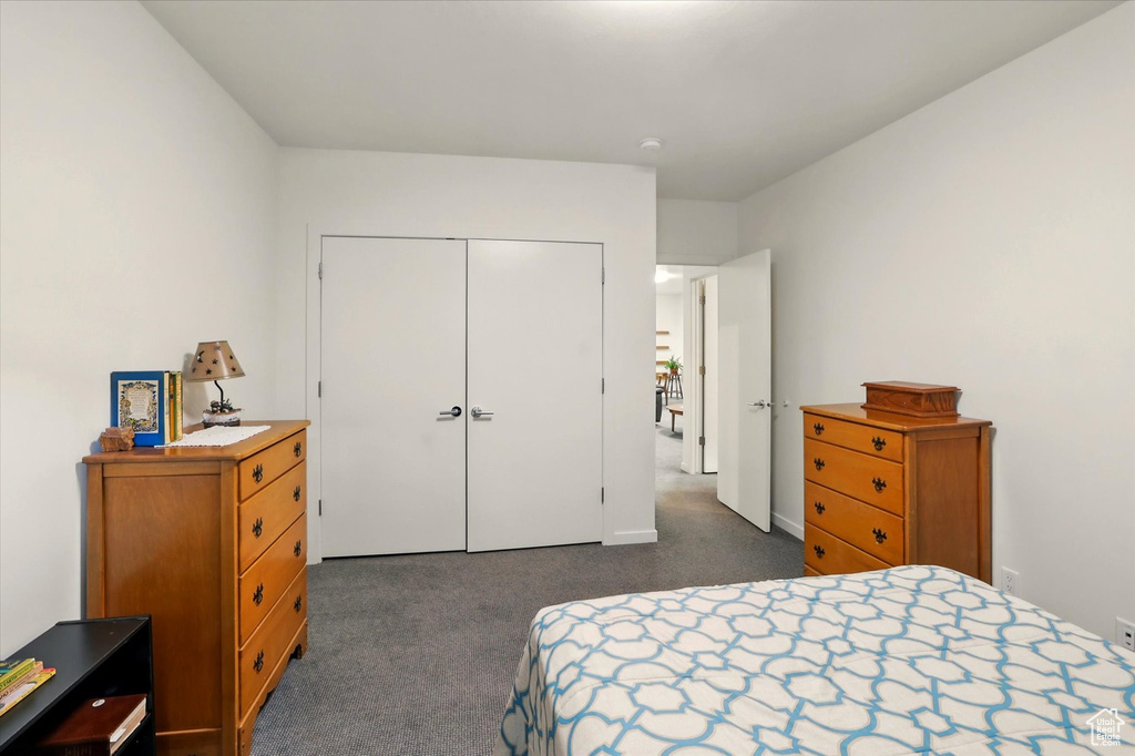 Bedroom with dark carpet and a closet
