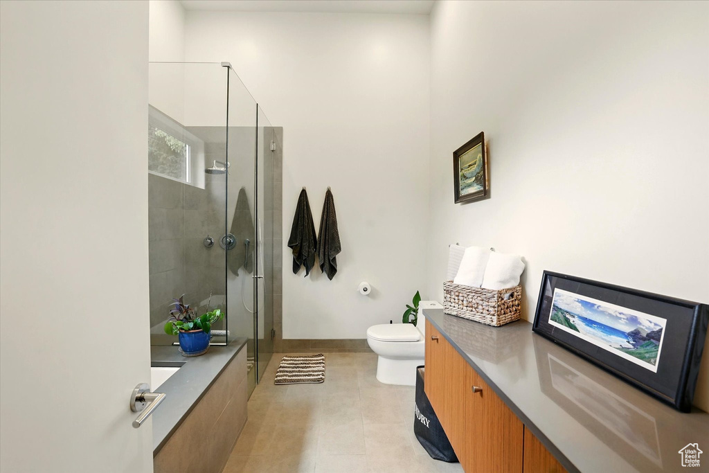 Full bathroom featuring a stall shower, vanity, toilet, and baseboards