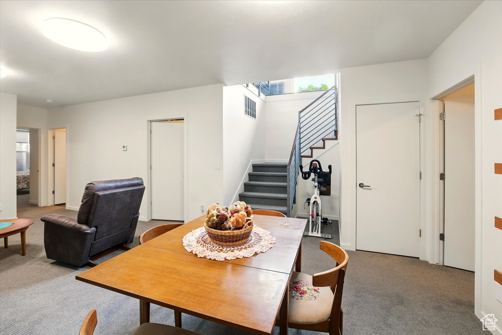 Dining space featuring carpet floors and stairs