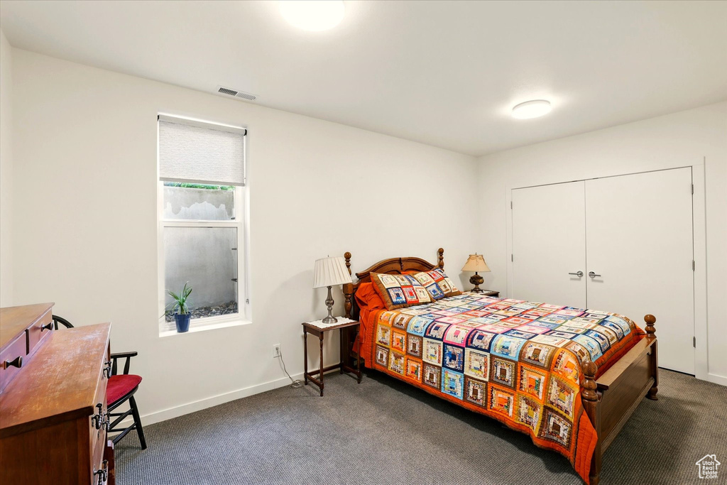 Carpeted bedroom featuring baseboards and a closet
