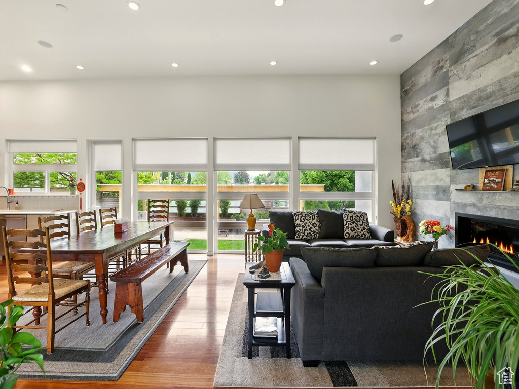 Living room with a towering ceiling, wood finished floors, a fireplace, and recessed lighting