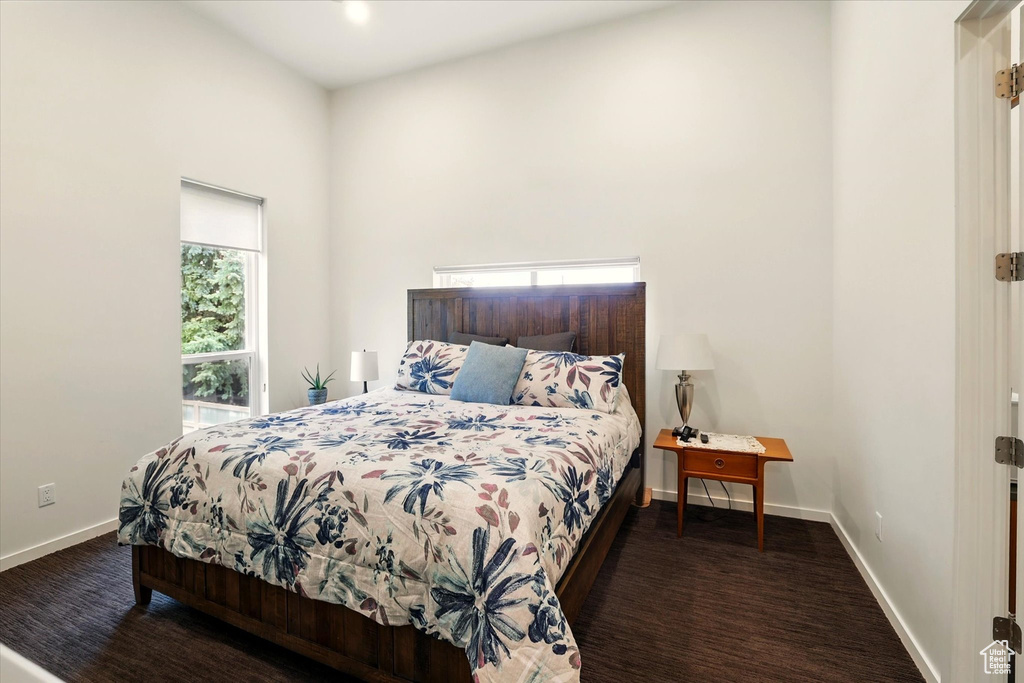 Bedroom featuring baseboards and a high ceiling