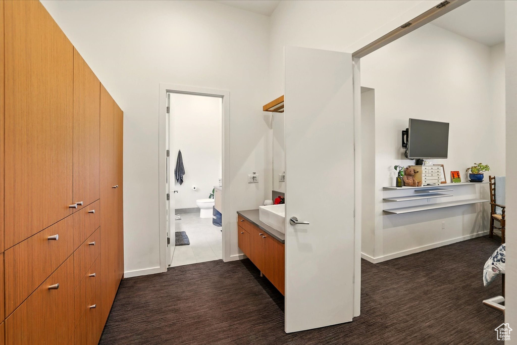 Bathroom featuring toilet, vanity, and baseboards