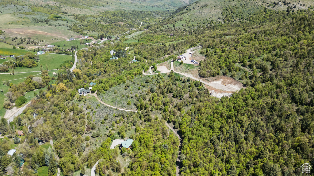 Aerial view of property and surrounding area with a forest