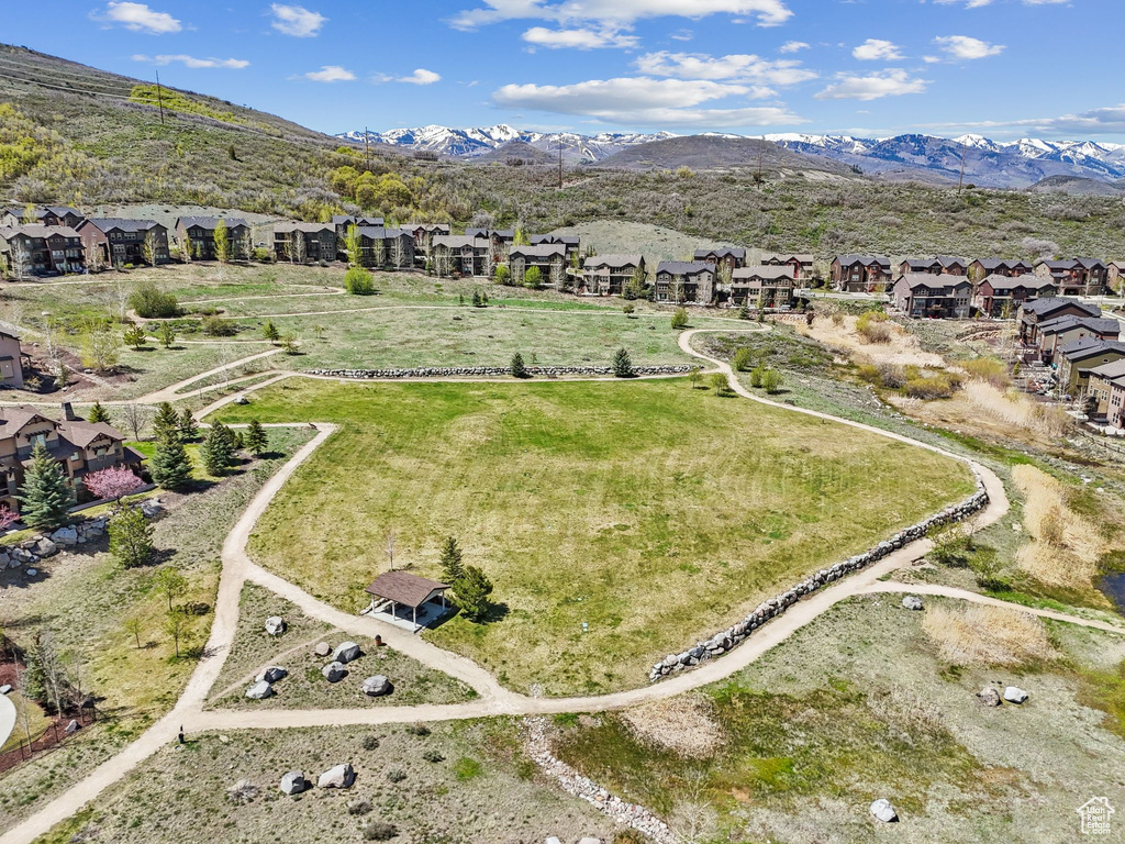 Aerial view of property and surrounding area featuring nearby suburban area and a mountain backdrop