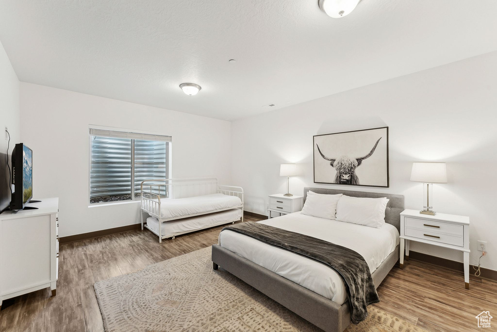 Bedroom with baseboards and wood finished floors