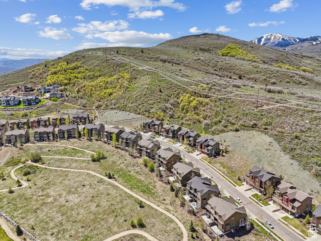 Aerial view of property and surrounding area with nearby suburban area and mountains