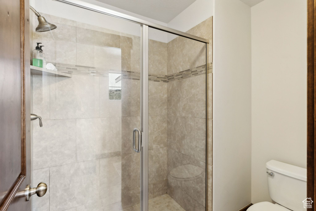 Full bathroom with toilet and a shower stall