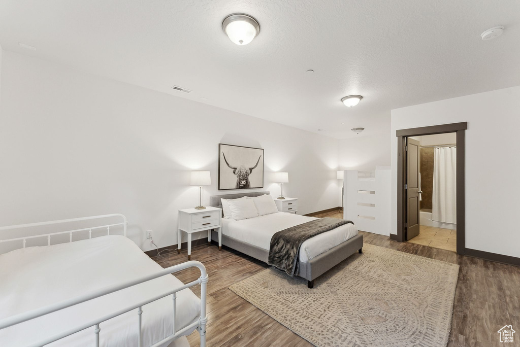 Bedroom with wood finished floors and baseboards
