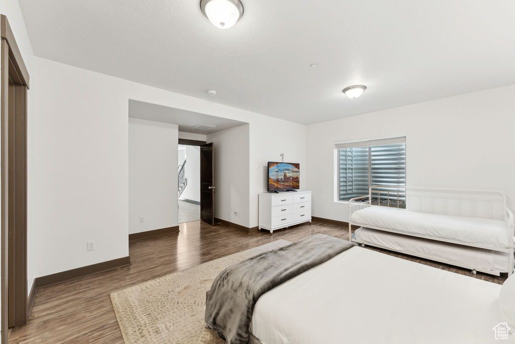 Bedroom with wood finished floors and baseboards
