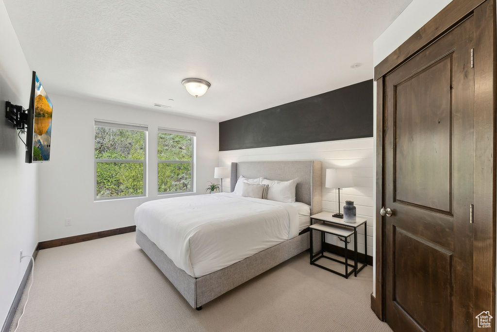 Bedroom featuring light colored carpet and baseboards