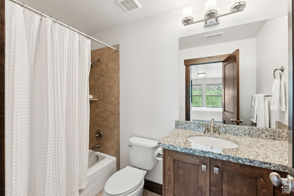 Full bathroom with shower / tub combo with curtain, vanity, and toilet