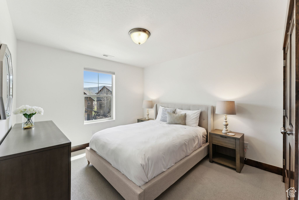 Bedroom featuring light colored carpet and baseboards