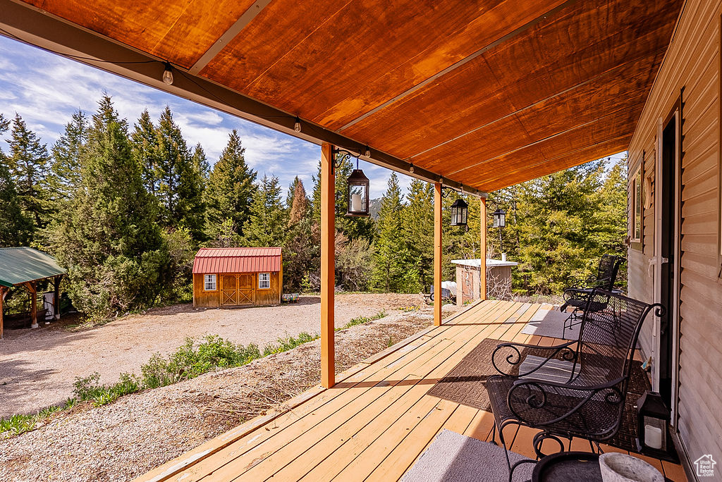 Deck featuring a storage unit and an outdoor structure