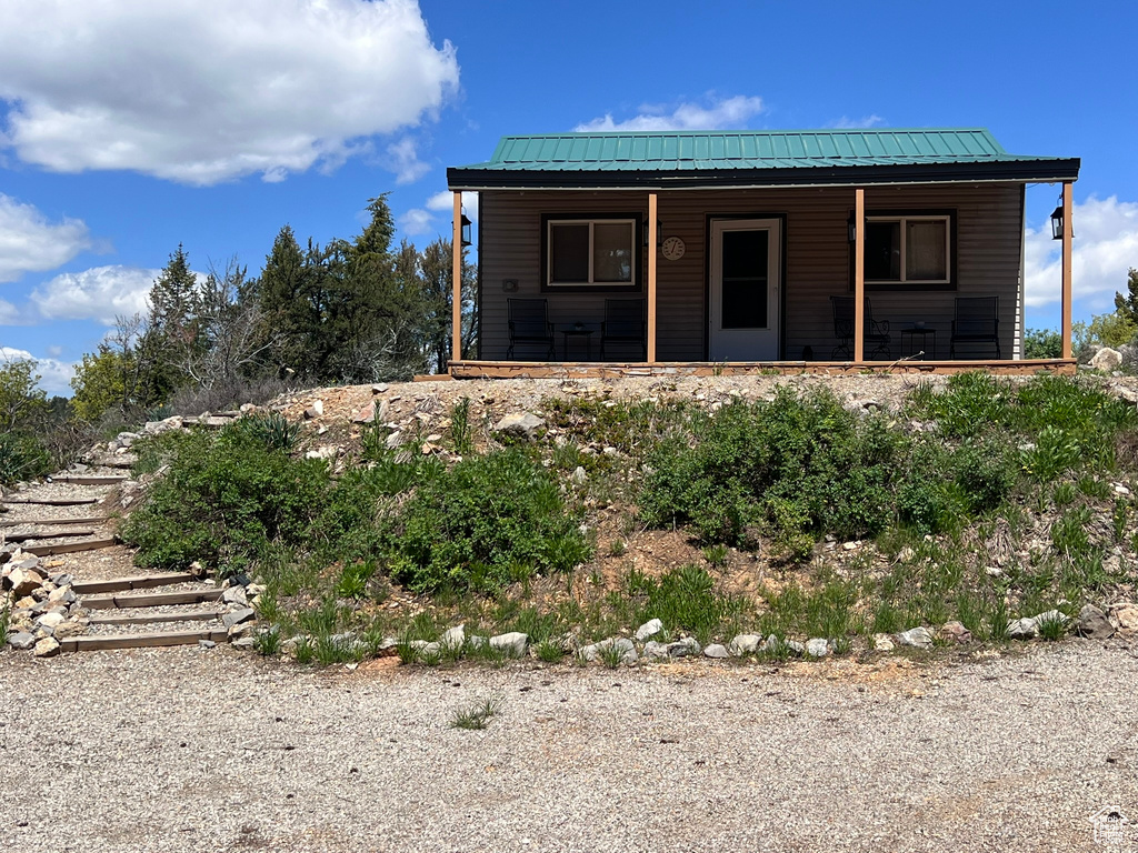 View of front of property featuring covered porch and metal roof