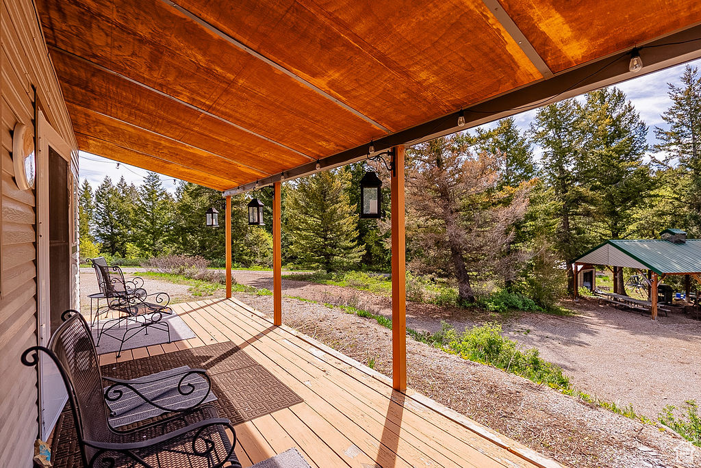 Wooden deck with a gazebo and view of scattered trees