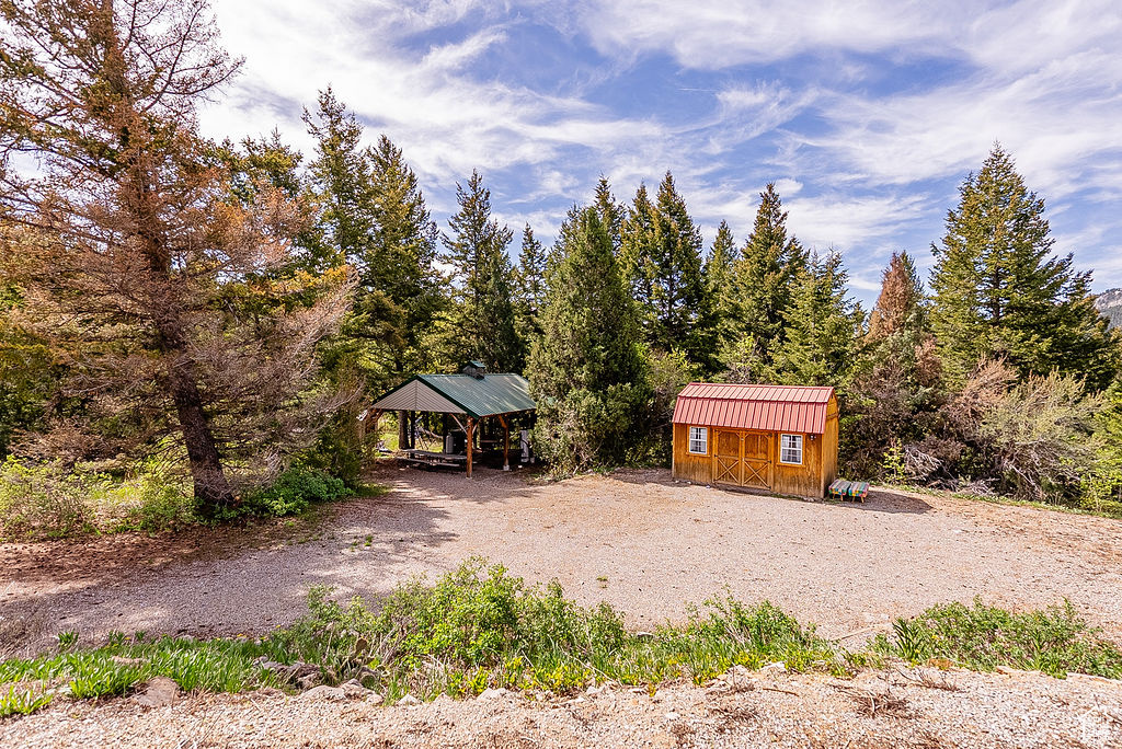 View of front facade with an outbuilding, a gazebo, a shed, and metal roof