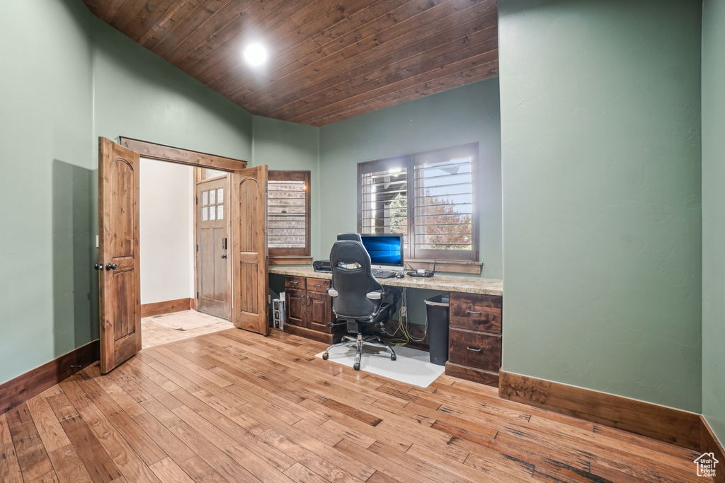 Office space with baseboards, lofted ceiling, light wood-type flooring, wood ceiling, and built in study area