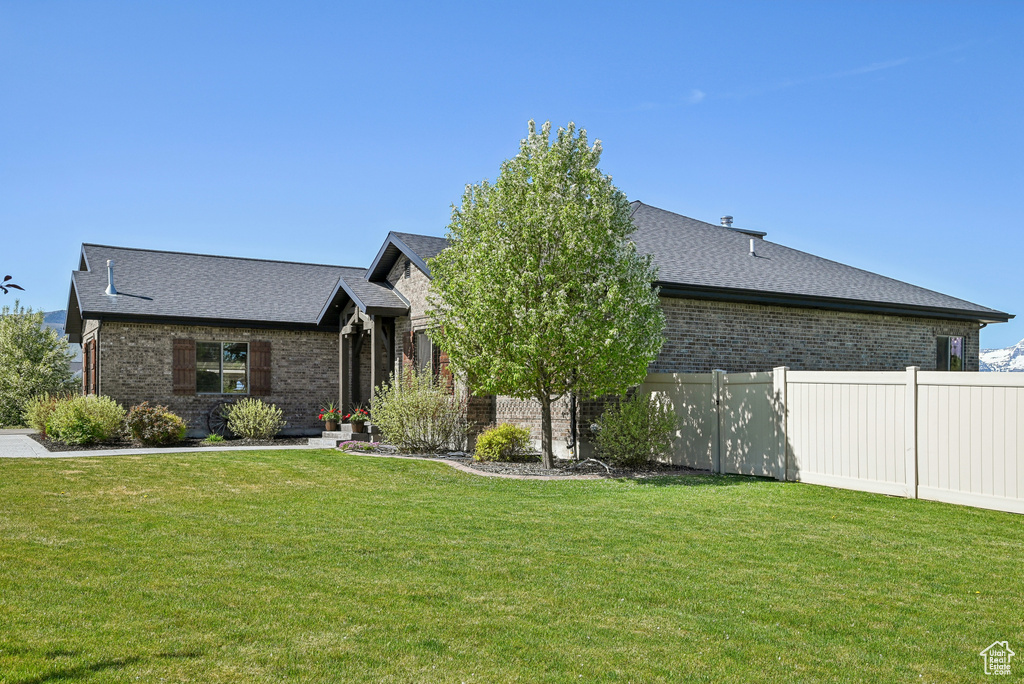 View of front facade with brick siding and roof with shingles