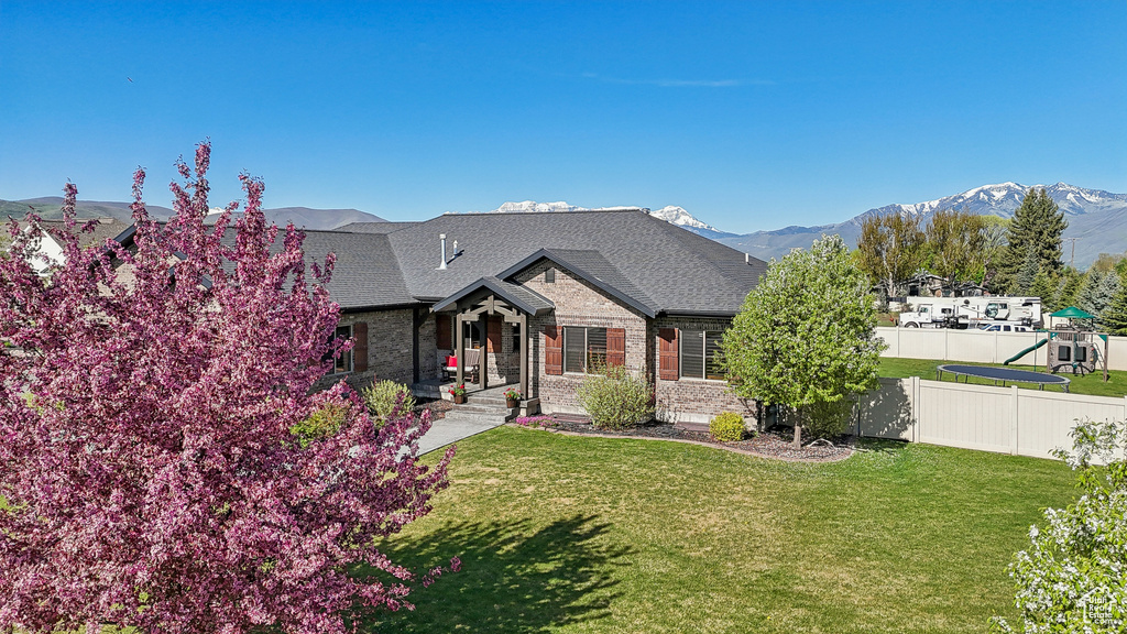 View of front of property with a mountain view, brick siding, a shingled roof, and covered porch