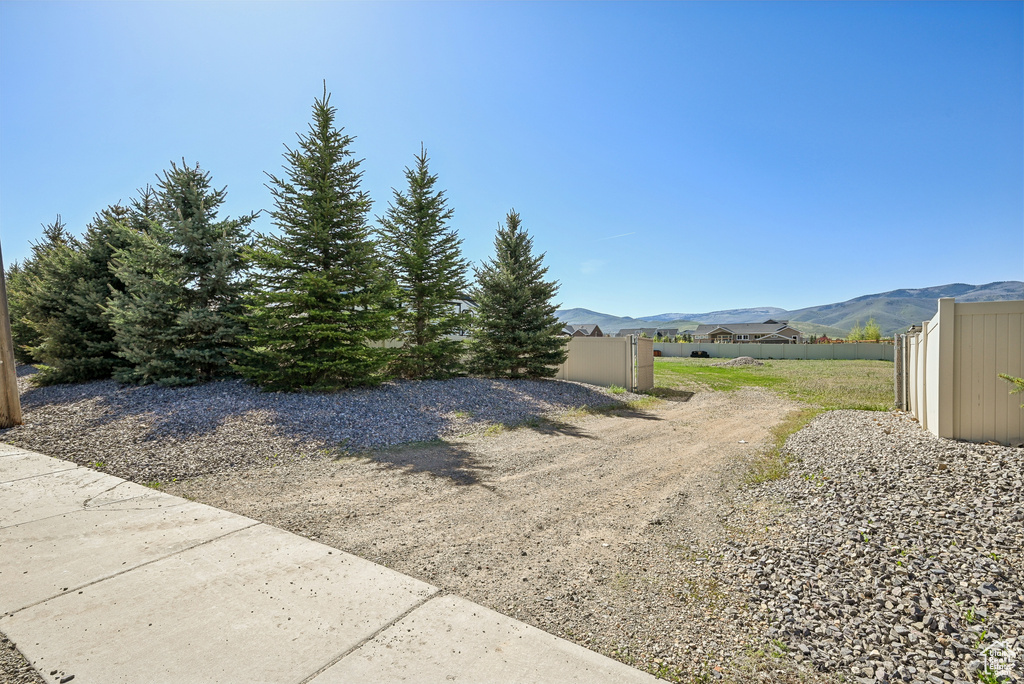 View of yard with fence and a mountain view