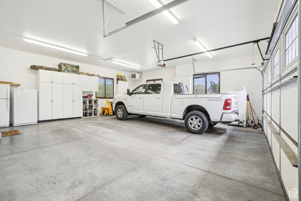 Garage featuring refrigerator, freestanding refrigerator, and a garage door opener