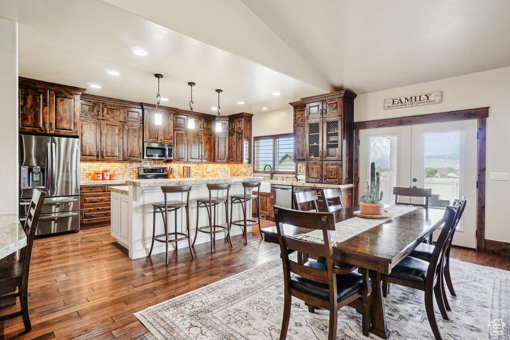 Dining space with recessed lighting, wood-type flooring, french doors, and lofted ceiling