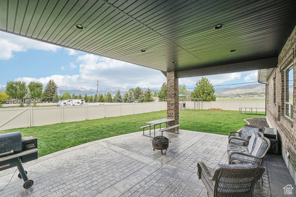 View of patio / terrace with a mountain view and an outdoor fire pit