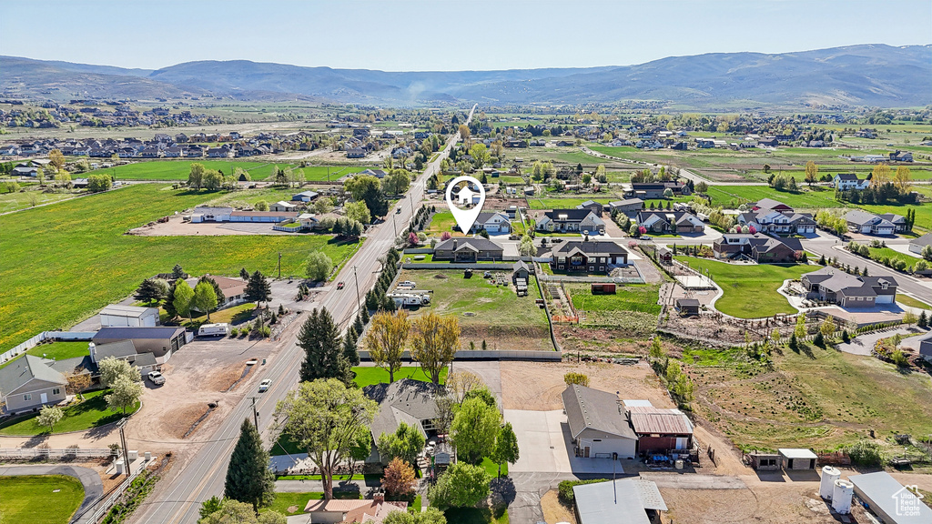 Aerial view of property and surrounding area with nearby suburban area and a mountainous background