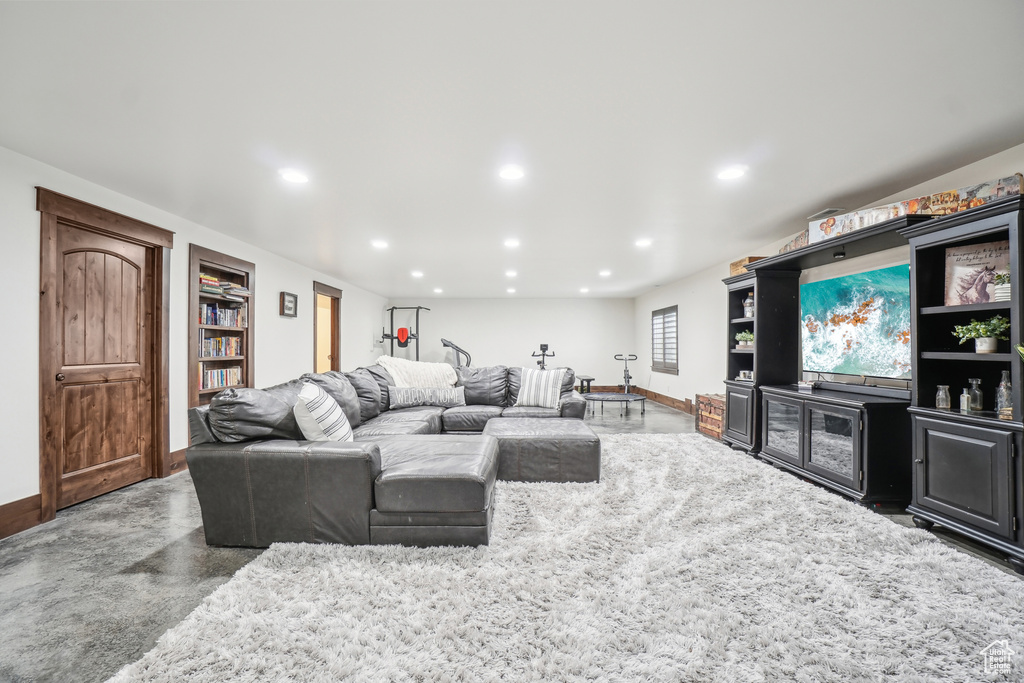 Living area featuring baseboards, recessed lighting, and finished concrete floors