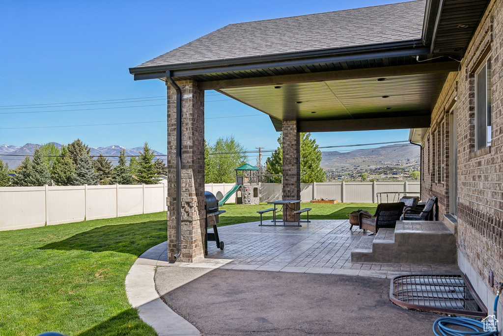 View of patio featuring a playground and a mountain view