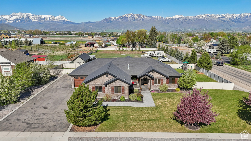 View of front facade featuring a mountain view, stone siding, driveway, and brick siding