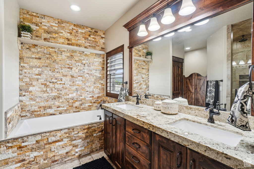 Full bathroom featuring tiled tub, tile patterned flooring, double vanity, and a tile shower