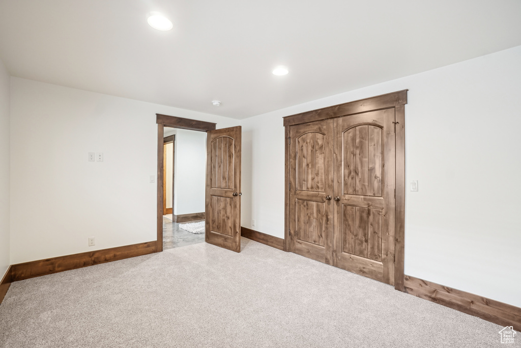 Unfurnished bedroom with carpet, baseboards, and recessed lighting